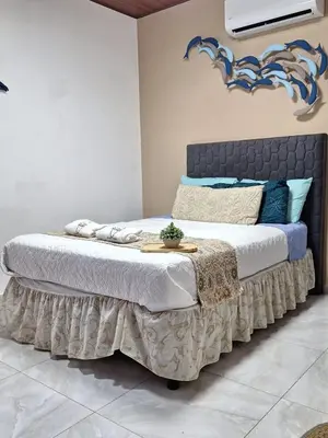 a bedroom with a large bed with a black headboard at Villa Surf Retreat in La Libertad