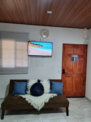 a couch in a living room with a flat screen tv at Villa Surf Retreat in La Libertad