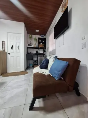 a living room with a couch and a television at Villa Surf Retreat in La Libertad