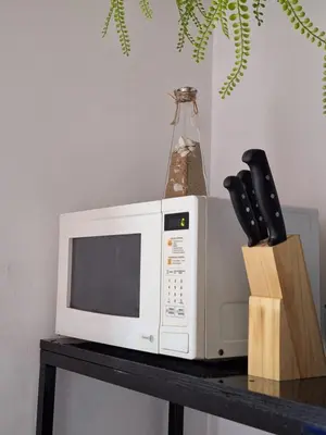 a microwave sitting on a table with knives at Villa Surf Retreat in La Libertad