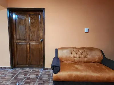 a brown leather couch sitting in front of a door at Linda casa con garaje en la majada