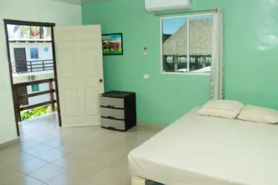 a bedroom with a white bed and a window at Beachfront Hotel near International Airport in Las Hojas