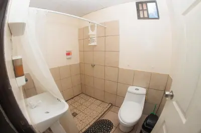 a small bathroom with a toilet and a sink at Beachfront Hotel near International Airport in Las Hojas