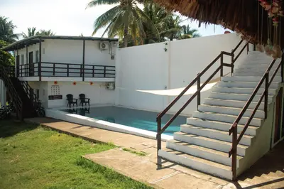 a staircase leading to a house with a swimming pool at Beachfront Hotel near International Airport in Las Hojas