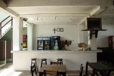 a bar with wooden tables and chairs in a restaurant at Beachfront Hotel near International Airport in Las Hojas