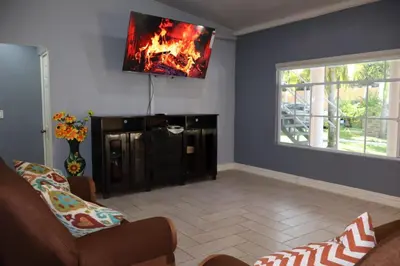 a living room with a fireplace and a tv on the wall at Costabay in El Zapote