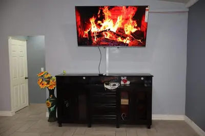 a living room with a fireplace with a tv on the wall at Costabay in El Zapote