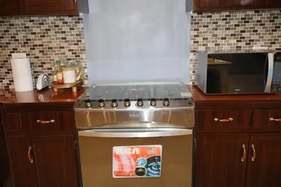 a kitchen with a stove and a microwave at Costabay in El Zapote