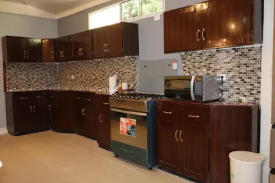 a kitchen with wooden cabinets and a stove top oven at Costabay in El Zapote