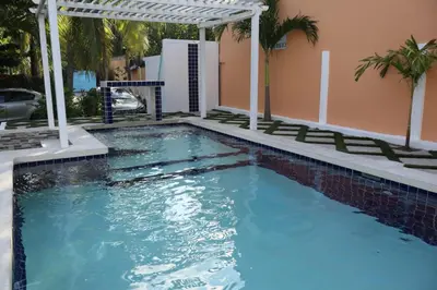a swimming pool with a pergola next to a house at Costabay in El Zapote