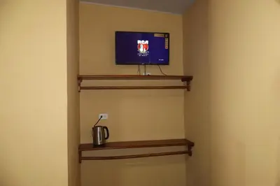 a room with a tv on a wall at habitacion costabay in San Luis La Herradura
