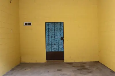 a yellow room with a door in the corner at habitacion costabay in San Luis La Herradura