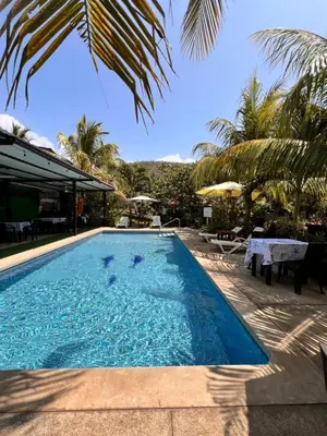 a swimming pool with palm trees and a resort at Mar Adentro San Blas in Playa San Blas