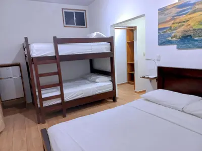 a room with two bunk beds and a bed at Mar Adentro San Blas in Playa San Blas