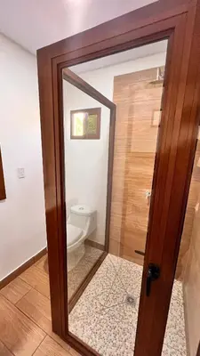 a bathroom with a toilet through a glass door at Mar Adentro San Blas in Playa San Blas