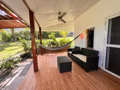 a screened in porch with a couch and a hammock at Mar Adentro San Blas in Playa San Blas