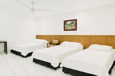a hotel room with two beds and a chair at Hotel Raíces Ataco in Concepción de Ataco