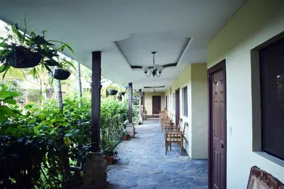 a hallway of a building with chairs and plants at Hotel Raíces Ataco in Concepción de Ataco