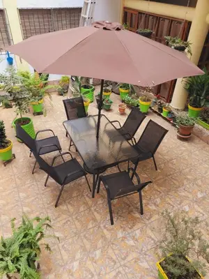 a table and chairs with an umbrella on a patio at El hostal de Uriel in Izalco