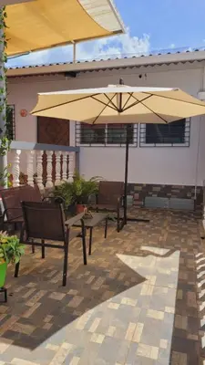 a patio with a table and a large umbrella at El hostal de Uriel in Izalco
