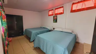 a room with two beds in a room at El hostal de Uriel in Izalco