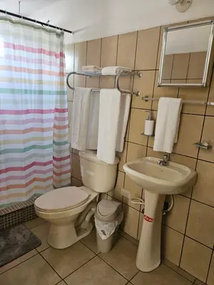 a bathroom with a toilet and a sink at El hostal de Uriel in Izalco
