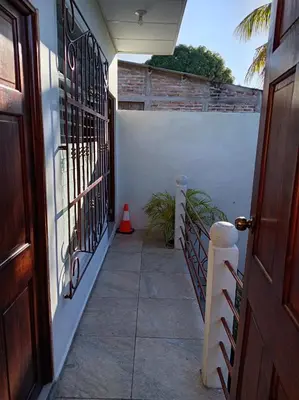a hallway of a house with a door and a staircase at Zacatecoluca House Hostel 2 nivel in Zacatecoluca