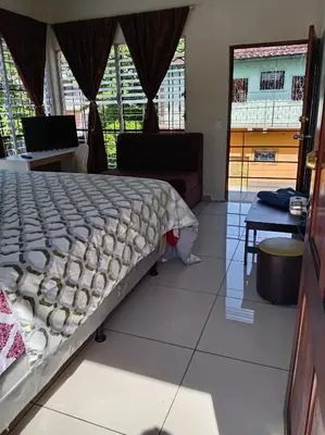 a bedroom with a bed and a couch and windows at Zacatecoluca House Hostel 2 nivel in Zacatecoluca