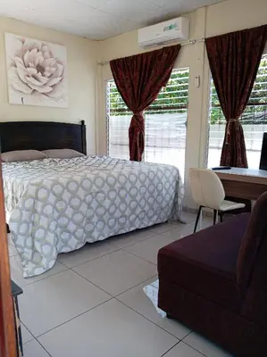 a bedroom with a bed and a desk and a desk at Zacatecoluca House Hostel 2 nivel in Zacatecoluca