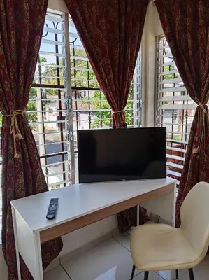 a television sitting on a desk in front of a window at Zacatecoluca House Hostel 2 nivel in Zacatecoluca