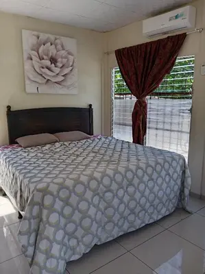 a bedroom with a large bed and a window at Zacatecoluca House Hostel 2 nivel in Zacatecoluca