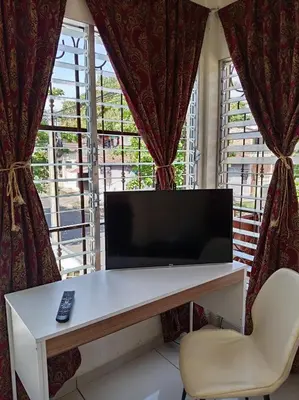 a living room with a tv and a table and a chair at Zacatecoluca House Hostel 2 nivel in Zacatecoluca
