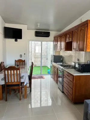 a kitchen with a stove and a dining room with a table at Casa de las villas 3 in San Miguel
