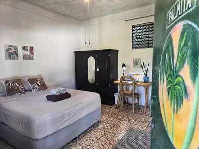 a bedroom with a bed and a table and a desk at 4 Amigos El Zonte in ChiltiupÃ¡n