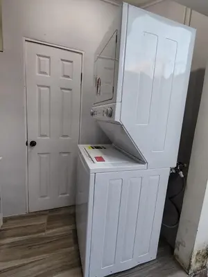 a kitchen with a white refrigerator next to a door at Veraneras House, your home in Santa Ana, El Salvador in Santa Ana