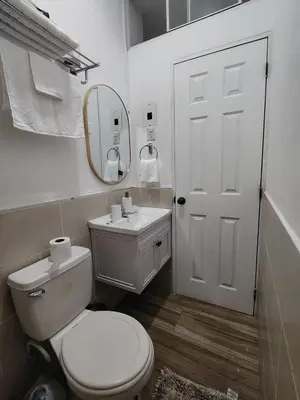 a bathroom with a toilet and a sink and a mirror at Veraneras House, your home in Santa Ana, El Salvador in Santa Ana