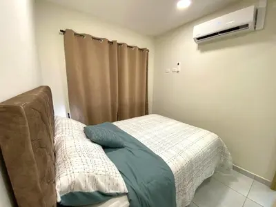 a bedroom with a bed and a window with a heater at Cozy house 5 minutes from the airport in Las Flores