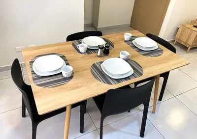 a wooden table with black chairs and white plates at Cozy house 5 minutes from the airport in Las Flores