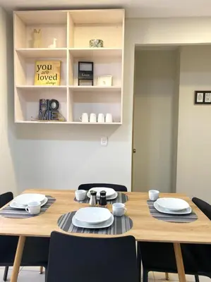 a wooden table with chairs and plates on it at Cozy house 5 minutes from the airport in Las Flores