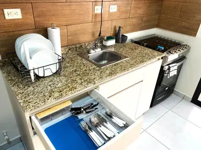 a kitchen with a sink and a counter top at Cozy house 5 minutes from the airport in Las Flores