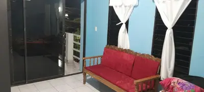 a red couch sitting in a room with a window at Hospedaje Mi Casita in Chalchuapa