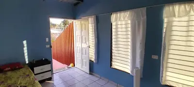a room with blue walls and two windows and a bed at Hospedaje Mi Casita in Chalchuapa