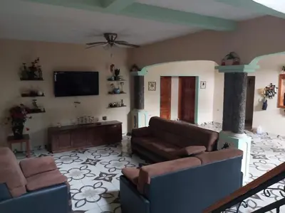 a living room with two couches and a flat screen tv at Ahuachapán Getaway