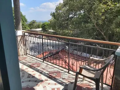 a balcony with a chair and a fence at Ahuachapán Getaway