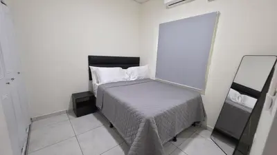a small bedroom with a bed and a mirror at La Casa de Miranda in San Miguel