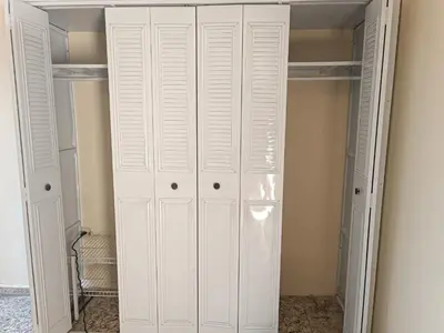 a white closet with white cabinets in a room at habitación doble cerca de todo in San Salvador
