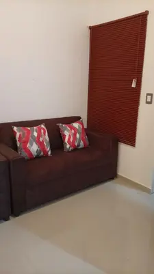 a brown couch with two pillows in a living room at Joseline House in San Miguel