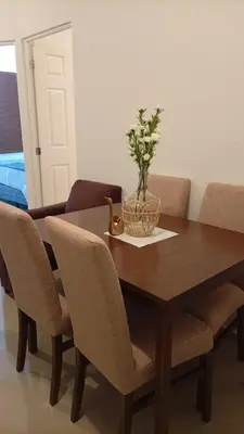 a wooden table with chairs and a vase with a plant on it at Joseline House in San Miguel