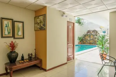 a hallway with a table and a swimming pool at Hotel Windsor Plaza in San Salvador