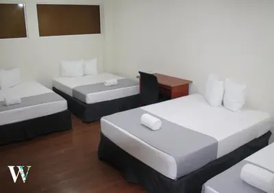 a hotel room with two beds and a desk at Hotel Windsor Plaza in San Salvador